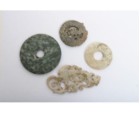 A collection of four Chinese hard stone carvings of various archaic designs including Bi discs, some possibly jade