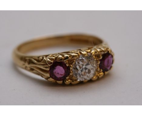 A fine quality Victorian style ladies 18ct gold ring set a large central diamond flanked by rubies in a carved mount