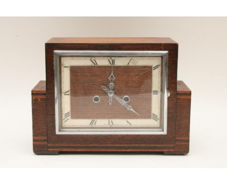 An Art-Deco, oak and chrome mantle clock of stylish design with inlaid banded decoration, the dial with chrome hands and deta