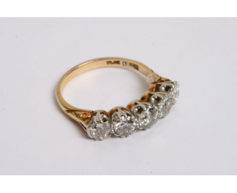 An 18ct gold ring inset with a graduation row of five diamonds