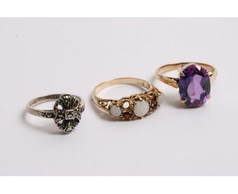 A gold opal set ring, another with purple stone and one other