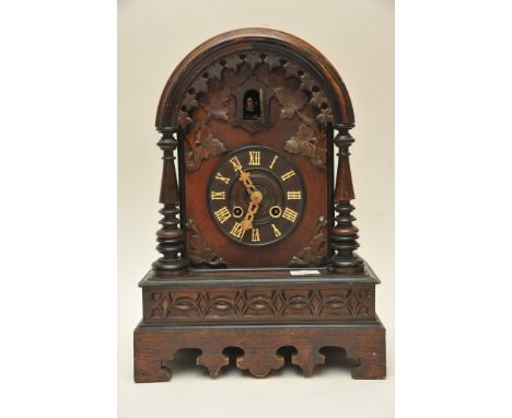 An oak cased cuckoo clock, the carved case with circular dial and Roman Numerals, pendulum and key. 