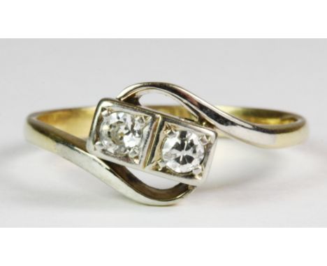 An 18ct yellow gold (stamped 18ct) crossover ring set with two brilliant cut diamonds (K.5).