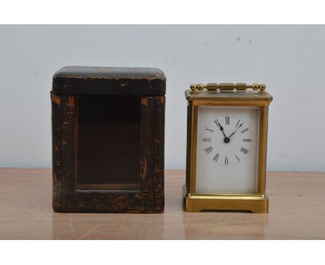 An early 20th century brass carriage clock, enamel dial with roman numerals, total height 12cm, with a fitted case and winder