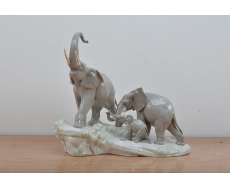 Lladro ceramic figural group, of three elephants, on a naturalistic base, marked to the underside, tusks AF, the base 41cm wi
