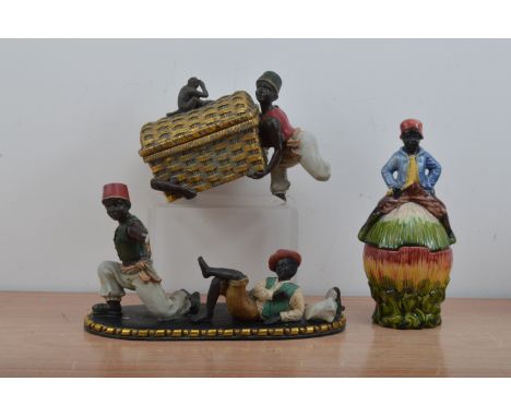 A majolica ceramic blackamoor covered vessel, the cover with a figurine of a black boy, 28cm high, together with a broken fig