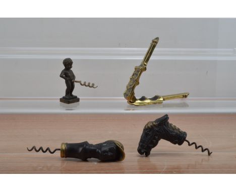 Three novelty cast metal corkscrews, one a jockeys head, another a horse and a cherub, together with a brass nut cracker, som