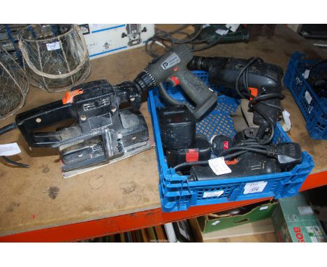Two "Black and Decker" drills and cordless drill with charger and a "Black and Decker" sander.