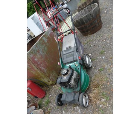 A "Qualcast" four stroke self propelled engine mower with grass collector (engine turns). 