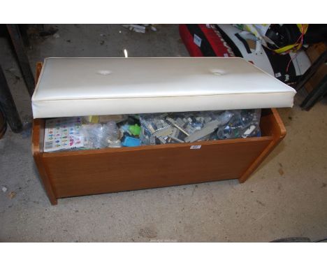 A wooden storage trunk full of Lego and toys.