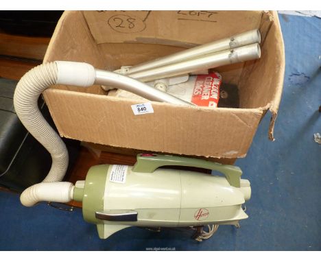 A vintage "Hoover" cylinder vacuum cleaner with accessories.