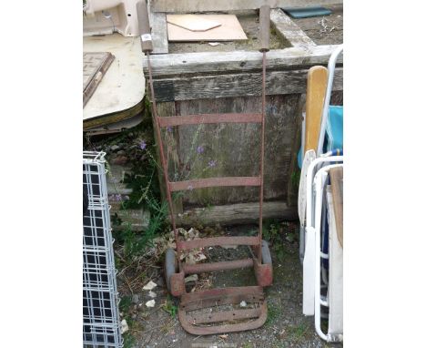 A vintage sack truck on solid wheels.