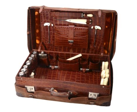 An early 20th century crocodile skin suitcase with silver fittings mainly by...  An early 20th century crocodile skin suitcas