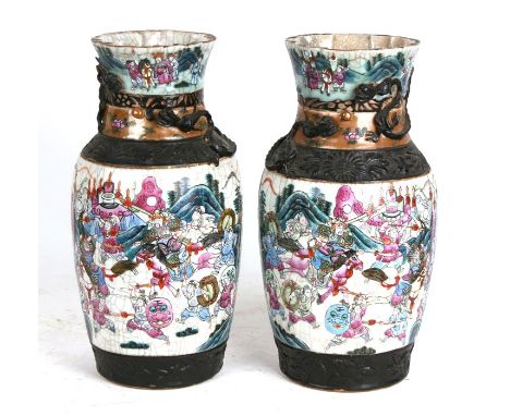A large pair of Chinese crackle glaze vases profusely decorated with warriors, with applied dragons to the neck, incised seal