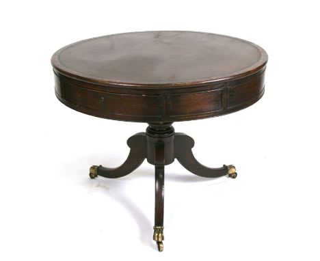 An oak drum table with inset leather top on turned column and tripod base. 92cm (36 ins) diameter