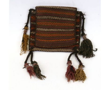 A Persian carpet salt bag with ornate tassels.