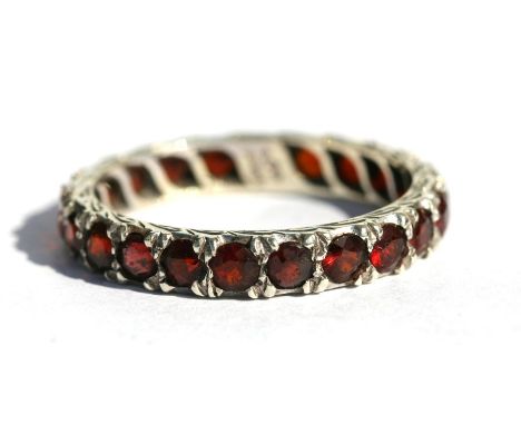 A 9ct white gold garnet set eternity ring, approx UK size 'P'.