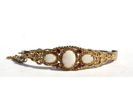 A late Victorian / Edwardian 9ct gold opal and ruby set bangle.Condition ReportOpals in good condition and is hallmarked