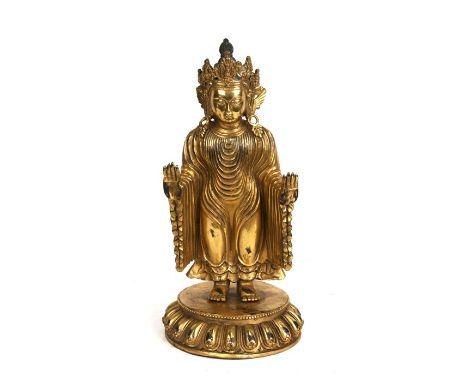 A Chinese gilded bronze standing robed Buddha figure, 33cms (13ins) high.