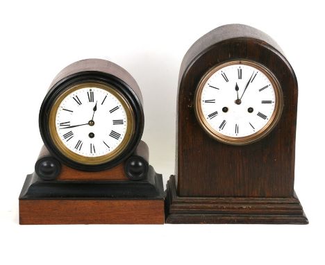 An Edwardian mantle clock with a 12cms diameter porcelain dial with Roman numerals, in a walnut drum case, 24cms (9.5ins) wid