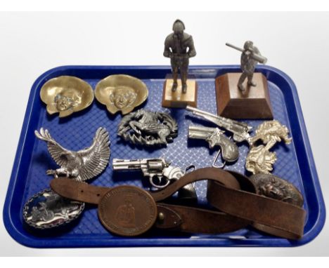 A group of diecast metal guns, brass portrait plaques, figure of a soldier and a knight on plinth, leather belt, etc.