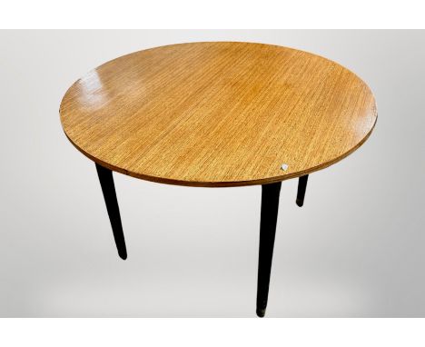 A 20th century oak circular dining table on tapered ebonised legs, 105 cm diameter x 72 cm high 