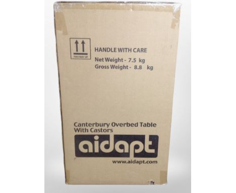 An Aidapt Canterbury over bed table with castors, sealed in packaging 