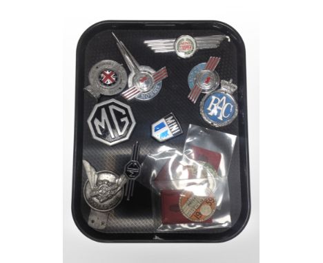 A group of vintage car badges and tax discs including MG, RAC, Morris, etc.