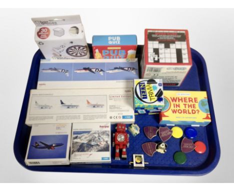 A tray containing enamel badges, Herpa miniature aircraft modelling kits, games, etc.