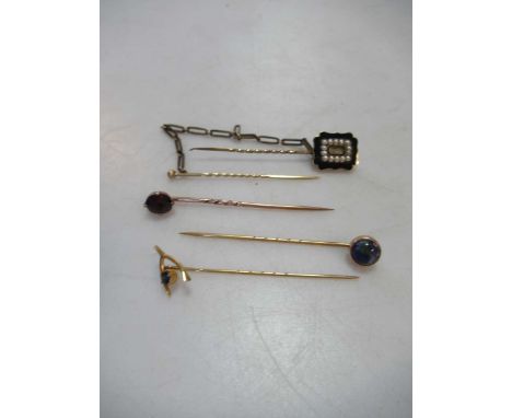 A memorial hat pin tested as 9ct gold, a garnet stick pin tested as 9ct gold, and a wishbone stick pin tested as 9ct gold, gr