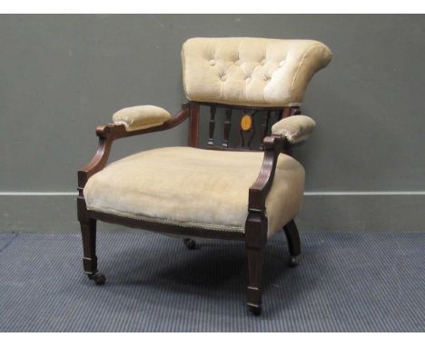 A late Victorian inlaid mahogany open armchair, the buttoned back rest over padded armrests on spade foot swaure tapering leg