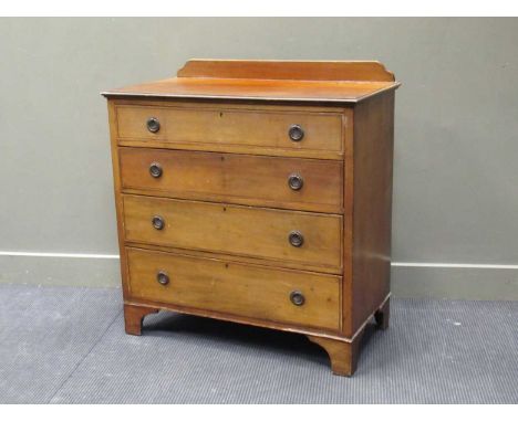 An Edwardian mahogany chest of drawers, the raised back above four long graduating drawers with ring handles and raised on br