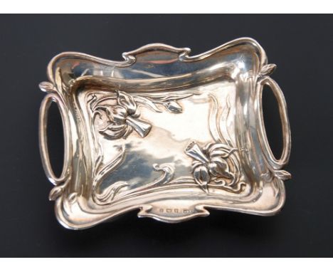 EDWARDIAN ART NOUVEAU SILVER TWO HANDLED SMALL TRINKET TRAY shaped oblong repousse with flowers and scrolling foliage, 4" wid