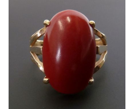 CORAL RING, four claw set with large oval coral, 5.7cm long, with pierced shoulders, stamped 14k band, K ½, 4.3g
