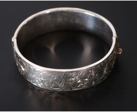 SILVER BROAD HINGE OPENING BANGLE, the top foliate scroll engraved, Birmingham 1955, 2 3/4oz