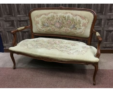 20TH CENTURY CARVED WOOD SETTEE OF FRENCH DESIGN, with needlework tapestry padded back, seat and arm rests, on carved legs wi