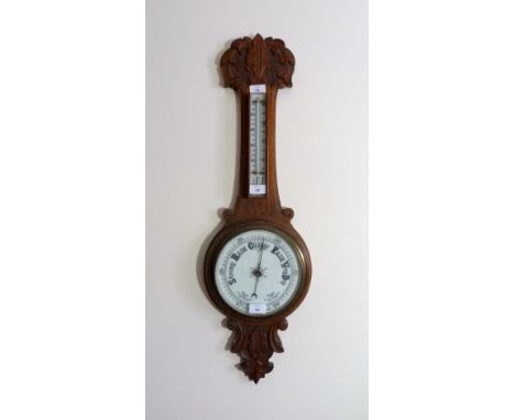 An Edwardian carved oak Aneroid Barometer and thermometer, 33½in (85cm) high. Provenance: Stoodley Knowle School, Torquay.