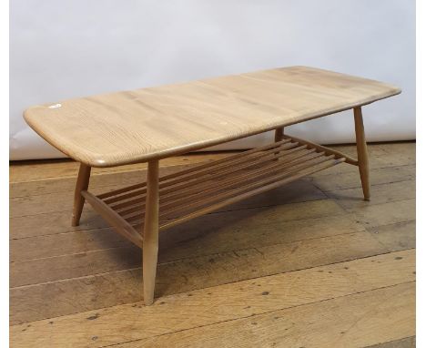 An Ercol elm two tier coffee table, 103 cm wideTop very light due to sun damage. Some stains and loss to varnish. BAse has va