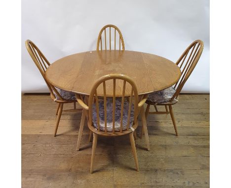 An Ercol light elm drop leaf dining table, 115 cm wide, and four Ercol hoop back dining chairsExtended 125 cm diameter, four 
