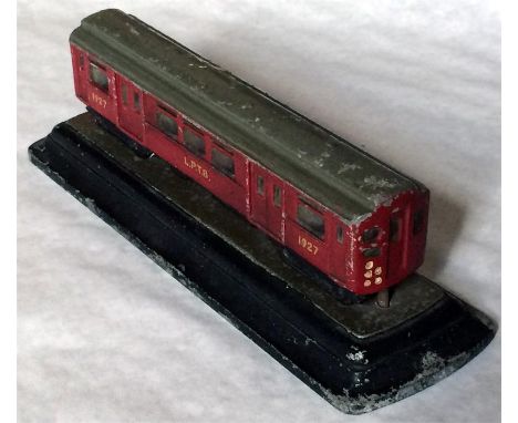 A 1930s alloy MODEL of a London Underground Q27-stock driving motor-car mounted on a plinth. The car is 6" (15cm) long and in