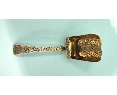 A Georgian silver caddy spoon of shovel form, with scroll and floral engraving, maker WE, London 1823.
