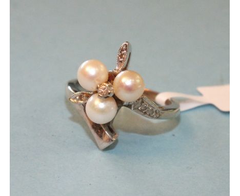 A 10ct white gold ring of asymmetric design set three cultured pearls and white stone accents, size K½, 4g. 