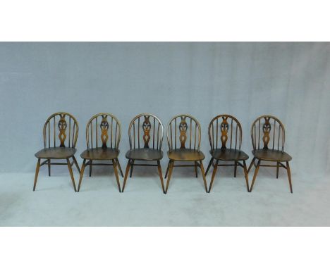 A set of six elm and beech Ercol Windsor wheel back dining chairs with makers label and kite mark stamped to base. H.80cm 