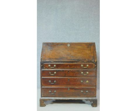 A Georgian mahogany bureau with fall front revealing fitted interior above four graduated drawers on ogee carved bracket feet