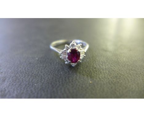 An 18ct White Gold Ruby and Diamond Cluster Ring - the central ruby approximately 6 mm x 5 mm x 3 mm - ring size Q - approxim