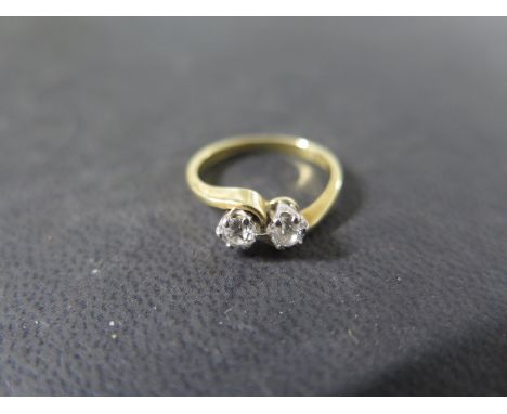 An 18ct yellow gold two stone diamond crossover ring - each diamond approx 0.15ct - ring size J - weight approx 2.7 grams - g