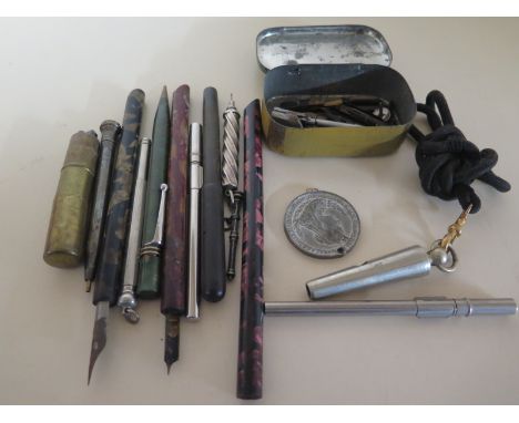 A collection of pens and pencils, a whistle and a trench lighter