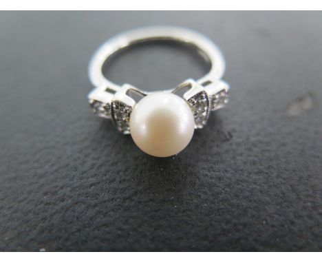 A 9ct white gold ring with 7mm cultured pearl flanked by six 2mm brilliant cut diamonds pave set weight 3.9 grams - size K 1/