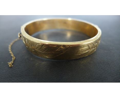 a 9ct Yellow Gold Bangle - 6 cm x 7 cm and approximately 19.5 grams - safety chain broken - some overall minor dents
