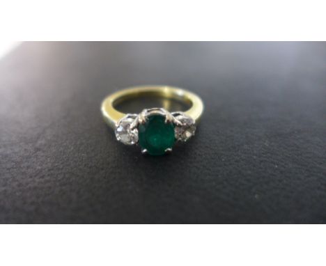 An 18ct Gold Emerald and Diamond 3 stone ring - size O, approx 5 grams - the central emerald measures approx 7.5 mm x 6 mm x 